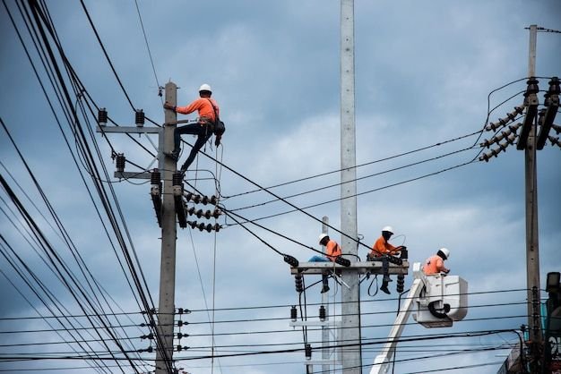 INICIO los electricistas se suben a postes eléctricos para instalar y reparar líneas eléctricas foto premium